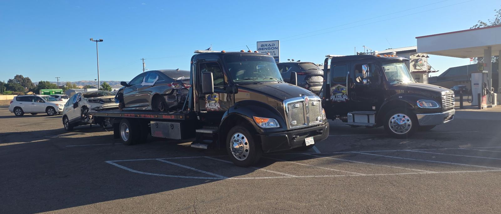 Two On The Go Towing trucks transporting damaged vehicles